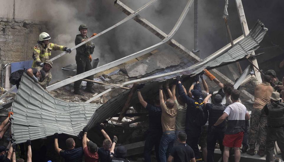 Rescuers and volunteers clean up the rubble and search victims after Russian missile hit the country's main children hospital Okhmadit in Kyiv, Ukraine, Monday, July 8, 2024. A major Russian missile attack across Ukraine killed at least 20 people and inju