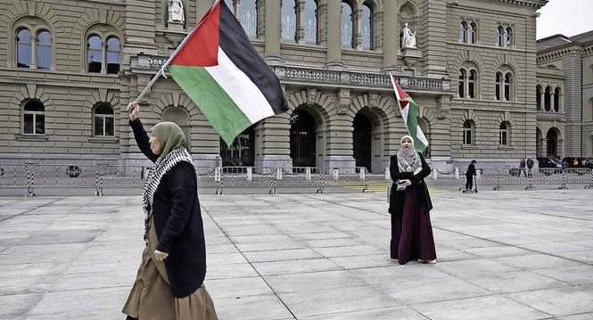 Demonstrantinnen halten Palaestina Flaggen hoch, waehrend einer Solidaritaetskundgebung fuer Gaza, am Samstag, 2. Maerz 2024 am dem Bundesplatz in Bern. (KEYSTONE/Peter Klaunzer)