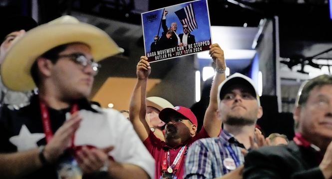 A delegate holds up a photo during the Republican National Convention Tuesday, July 16, 2024, in Milwaukee. (AP Photo/Nam Y. Huh)