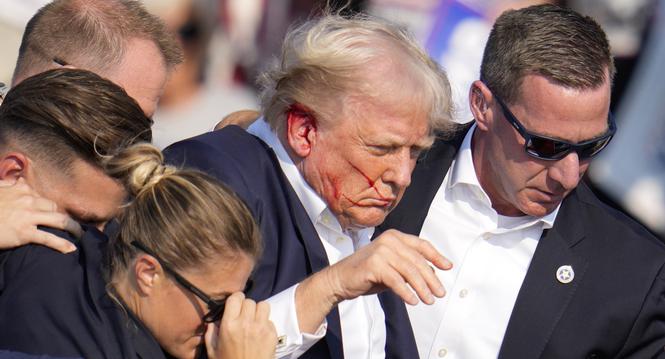 Republican presidential candidate former President Donald Trump is helped off the stage at a campaign event in Butler, Pa., on Saturday, July 13, 2024. (AP Photo/Gene J. Puskar)