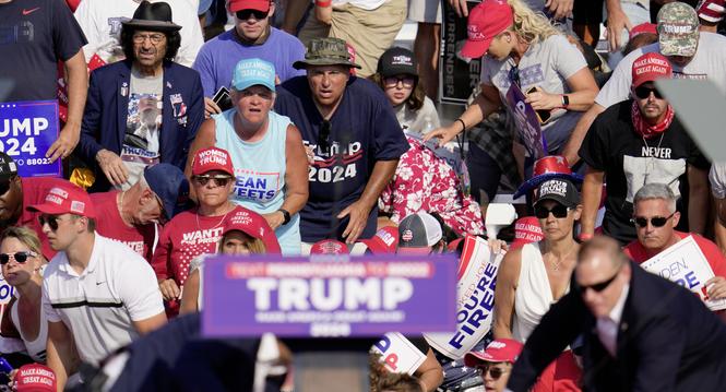 The crowd reacts as Republican presidential candidate former President Donald Trump is surrounded by U.S. Secret Service agents at a campaign event in Butler, Pa., on Saturday, July 13, 2024. (AP Photo/Gene J. Puskar)